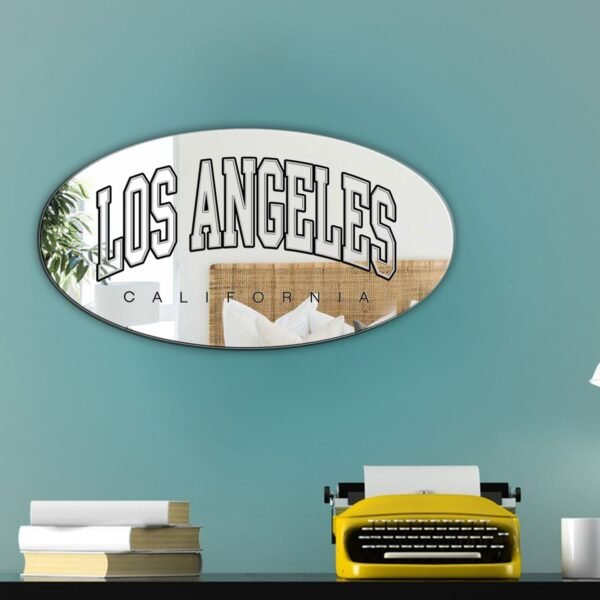 White oval mirror featuring black painted 'Los Angeles' varsity text.