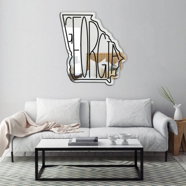 Round Georgia mirror with a gold frame on a white wall.