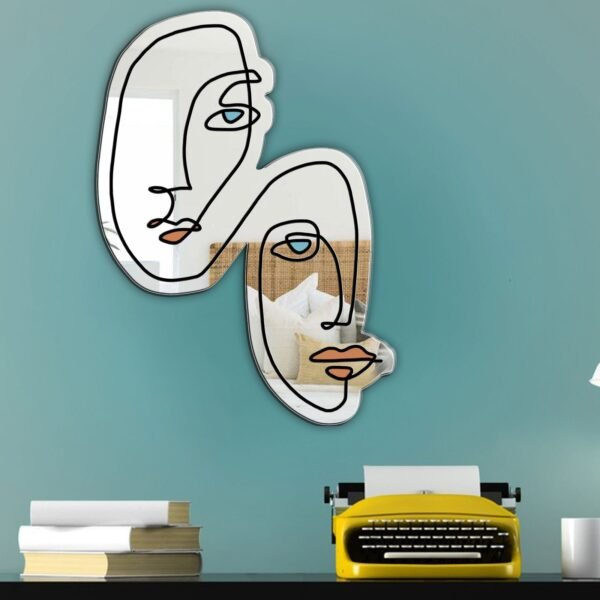 Wall mirror with minimalist face outline in black.
