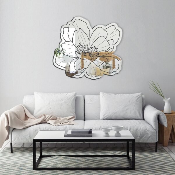 Round mirror surrounded by delicate metal flower petals.