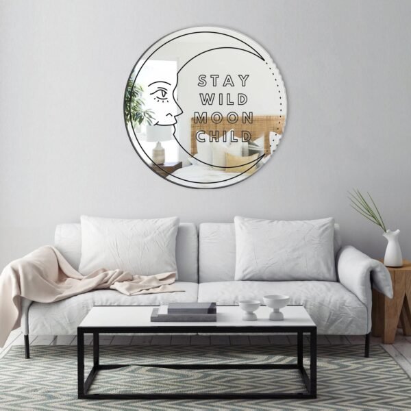 Decorative mirror shaped like a moon with whimsical script.