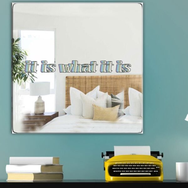 A stylish mirror with the motivational quote "It is what it is" displayed in bold, minimalist typography.