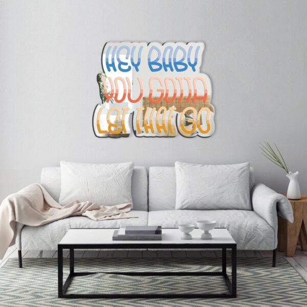 A custom-painted mirror featuring the meditation quote "Hey Baby Let That Go.