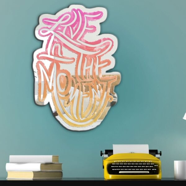 A custom-painted mirror featuring the phrase "Live in the Moment" with a sunset design.