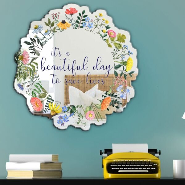 A decorative mirror featuring a wildflower floral design with the phrase "It's a beautiful day to save lives," combining inspiration with nature.