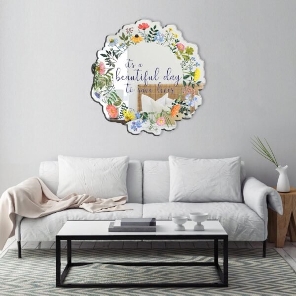 A decorative mirror featuring wildflowers and the phrase "It's a beautiful day to save lives," offering a blend of inspiration and nature.