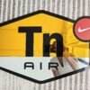 A custom mirror shaped like the TN AIR NIKE logo, featuring gold and silver accents