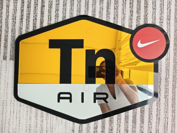 A custom mirror shaped like the TN AIR NIKE logo, featuring gold and silver accents