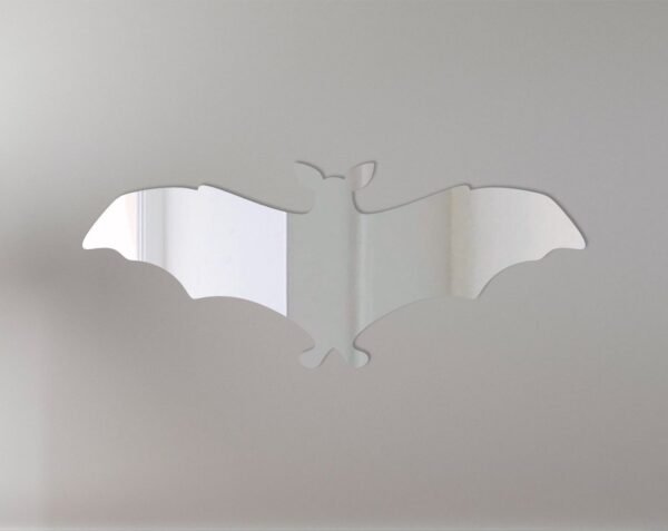 Reflective wall mirror shaped like a flying bat.