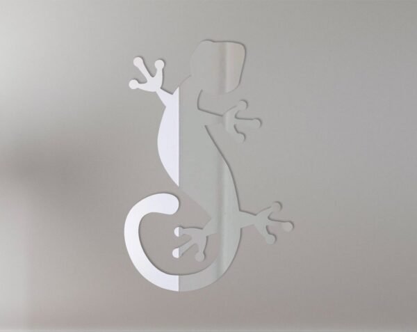Round mirror with a gold Gekko lizard design on top.