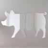 Pink pig-shaped mirror with 'Welcome' sign hanging on a rustic wooden fence.