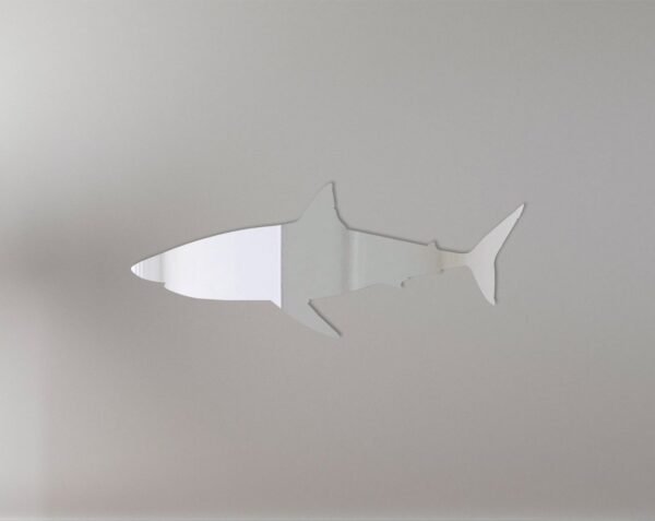 Shark-shaped mirror with '3' and sign accents on wooden board.