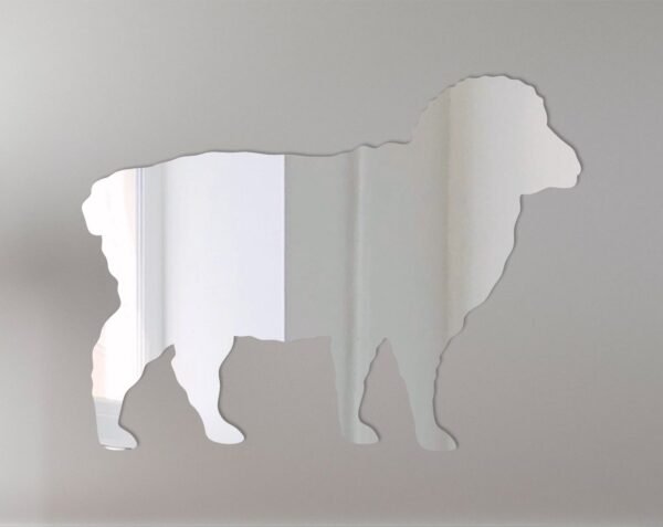 Sheep-shaped mirror with 'Welcome' sign hanging on a barn door.