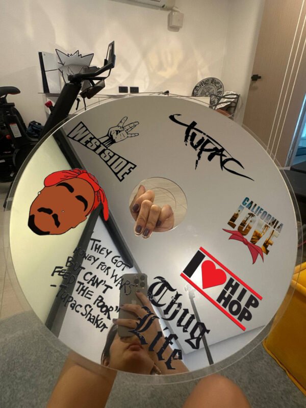 Hip-hop tribute CD mirror featuring Tupac designs and inspirational quotes in a creative space