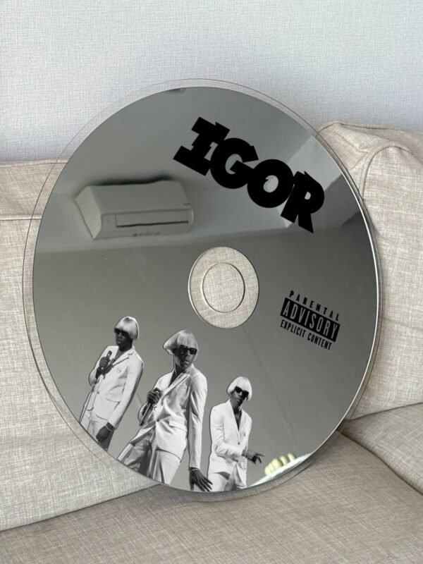 IGOR album-themed CD mirror with a reflective surface, mounted on a wall.